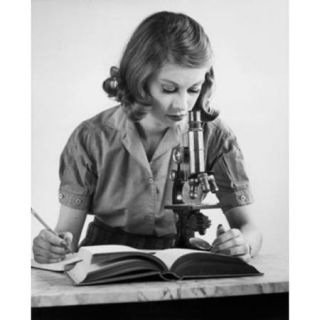 Teenage girl looking through a microscope Poster Print (18 x 24)